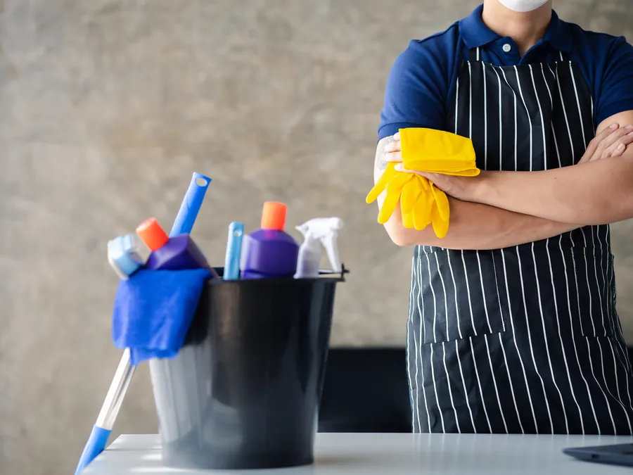 CleanerWA cleaner with a bucket of cleaning supplies